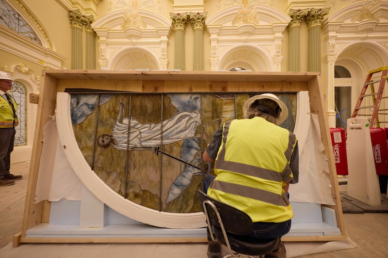 Um trabalhador limpa uma peça de vidro artístico com Adam e Eve durante a instalação na terça-feira, 21 de abril de 2026, em Salt Lake City. A obra de arte estará na sala celestial do Templo de Salt Lake de A Igreja de Jesus Cristo dos Santos dos Últimos Dias.