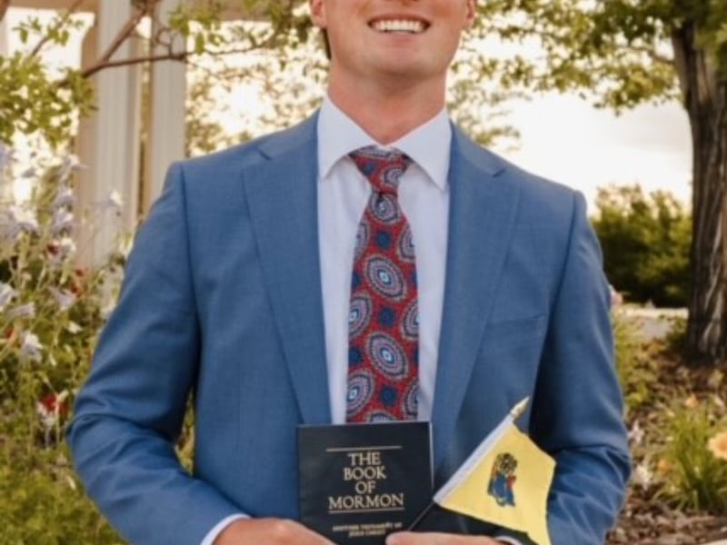 A full-time missionary of the Church of Jesus Christ holds a Book of Mormon.