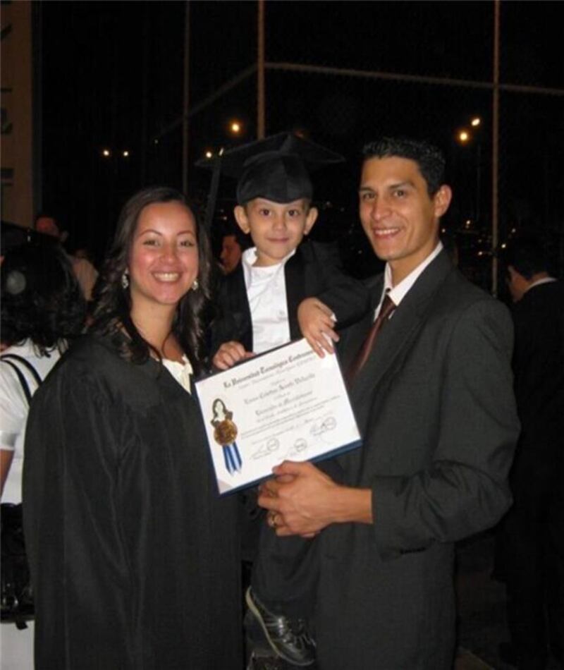 Hector David e Emma Hernandez posam com seu filho jovem Oscar David, que está segurando o diploma de Emma da Universidad Tecnológica Centroamericana em Tegucigalpa, Honduras, em março de 2011.