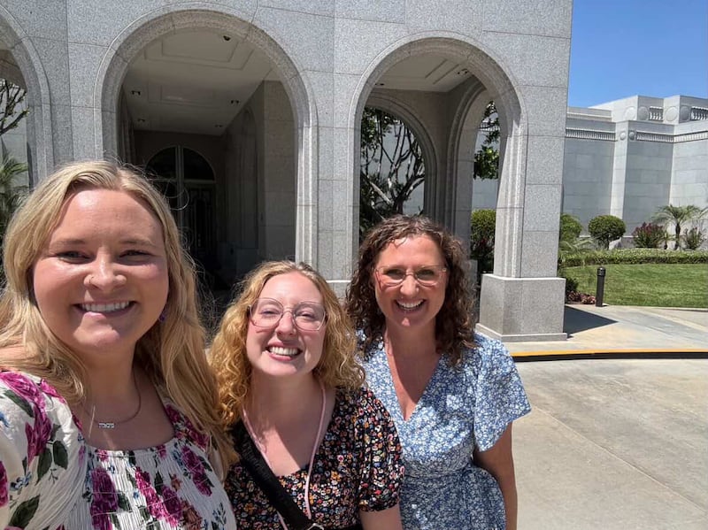 Jovens adultos solteiros sorriem para uma foto do lado de fora do Templo de Redlands Califórnia durante a conferência 2025 ASL YSA. A conferência ocorreu de 14 a 18 de agosto de 2025.