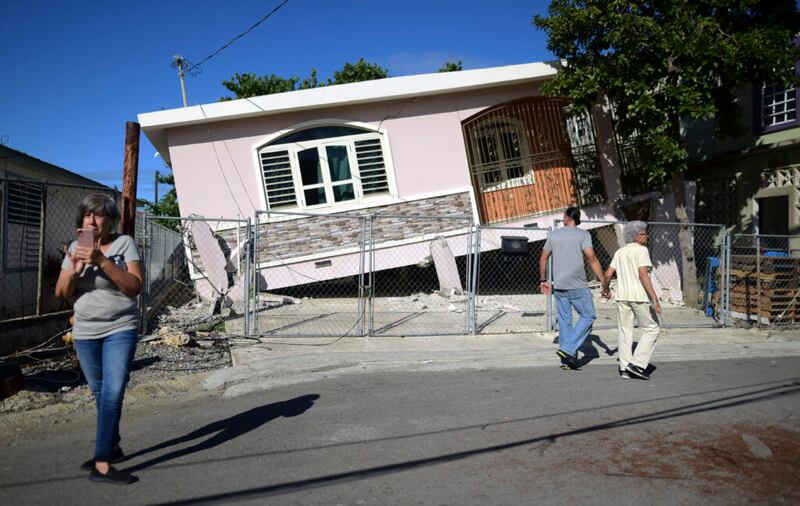 Moradores avaliam os danos onde uma casa caiu parcialmente depois que um terremoto atingiu Guánica, Porto Rico, na segunda-feira, dia 6 de janeiro, 2020. Um terremoto de magnitude 5,8 atingiu Porto Rico antes do amanhecer na segunda-feira, desencadeando pequenos deslizamentos de terra, causando falta de energia e graves rachaduras em algumas casas. Até o momento, não há nenhum relato de vítimas.