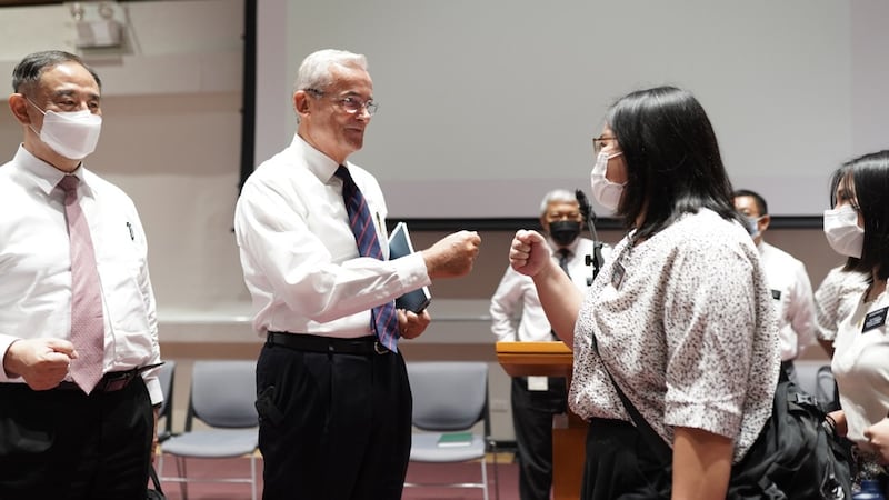 Élder Patrick Kearon, da Presidência dos Setenta, e Élder Yoon Hwan Choi, conselheiro na presidência da Área Filipinas, cumprimentam os missionários após o devocional no domingo, 21 de agosto de 2022.
