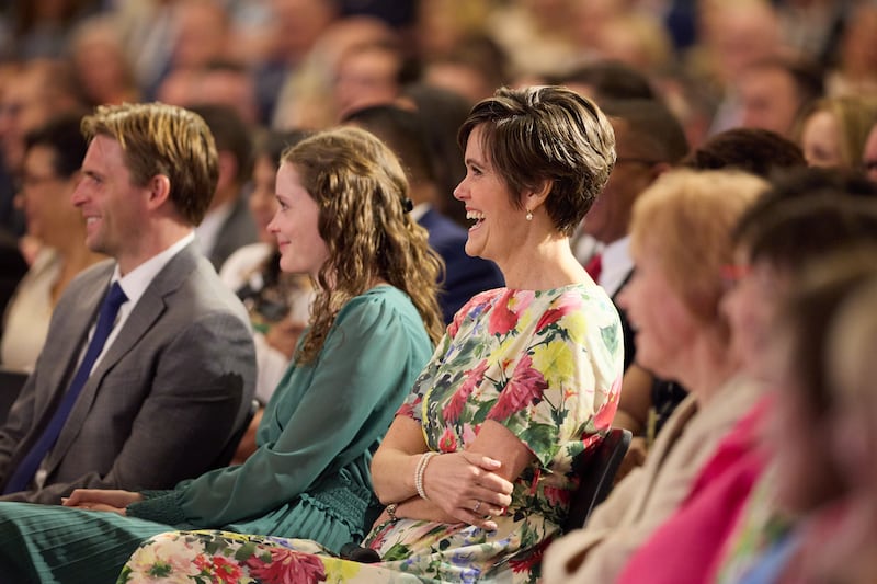 A irmã Jennifer Kearon, esposa de Élder Patrick Kearon, do Quórum dos Doze Apóstolos, ri enquanto o marido discursa no Seminário de 2026 para Novos Líderes de Missão, no Centro de Treinamento Missionário de Provo, em Provo, Utah, no sábado, 20 de junho de 2026.