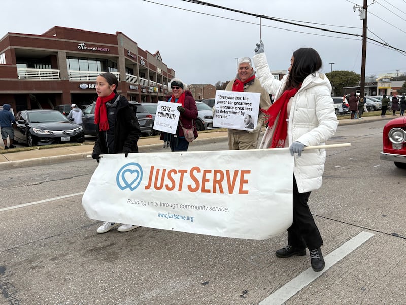 Volunteers walk in the Martin Luther King Jr. Day parade on Saturday Jan. 17, 2025, in Carrollton, Texas.