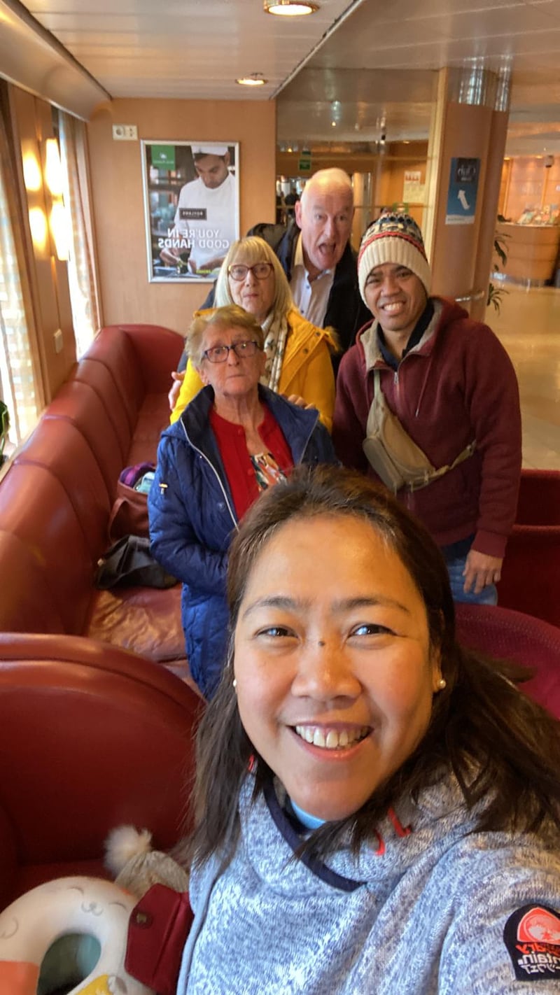 Da frente para trás: Roan Ducusin, Mary Holmes, Sigfred Ducusin, Charlotte Tiernan e Joe Tiernan sorriem enquanto estão na balsa para viajar para o Templo de Preston, Inglaterra, de Sligo, Irlanda, em 14 de outubro de 2025.
