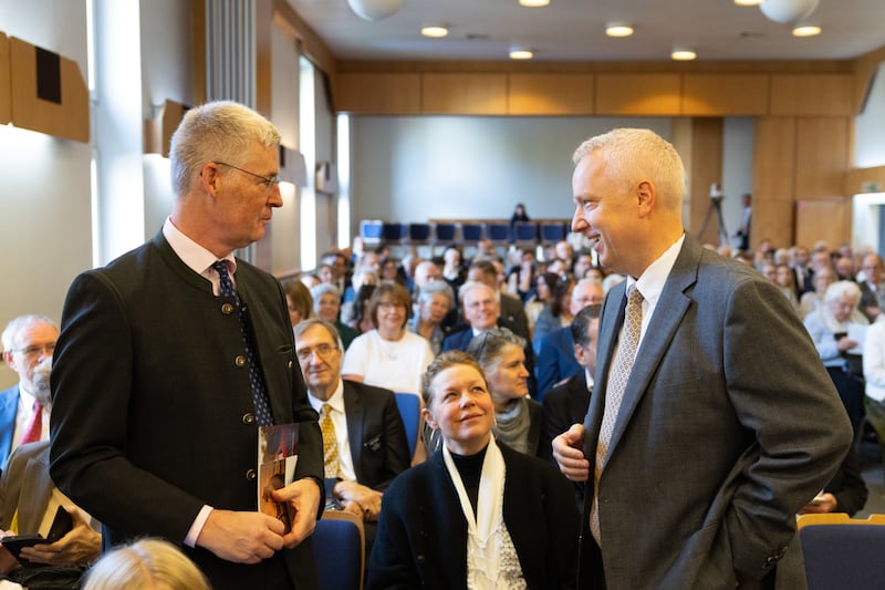 Élder Michael Cziesla — um Setenta Autoridade Geral e membro da presidência da Área Europa Central da Igreja — conversa com um participante dentro de um salão de reuniões antes da cerimônia de lançamento da pedra fundamental do Templo de Viena Áustria em Viena, Áustria, em 17 de outubro de 2026.