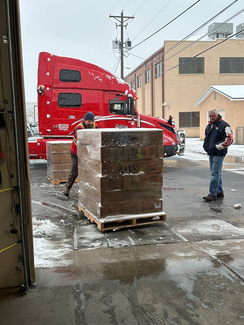 Voluntário John Bush, à esquerda, empurra uma palete de alimentos para dentro do Depósito Cooperativo de Pueblo enquanto o secretário executivo da Estaca Pueblo Colorado, Bruce Dwelle, à direita, supervisiona o trabalho, em 3 de dezembro de 2025.