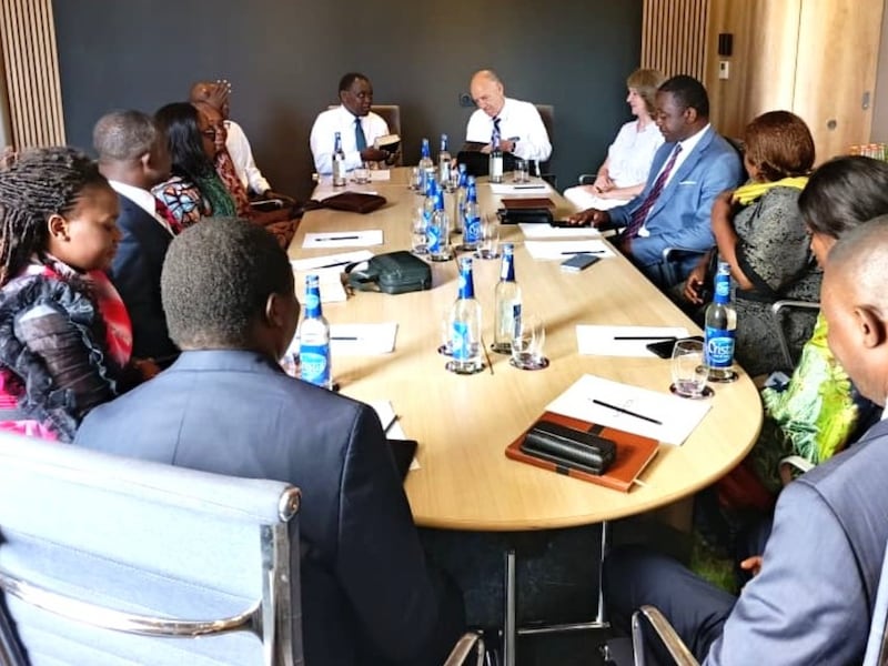 Elder Edward Dube e Elder Paul B. Pieper lideram uma discussão em grupo focal ao redor de uma mesa em Lubumbashi, República Democrática do Congo, 30 de abril de 2026.