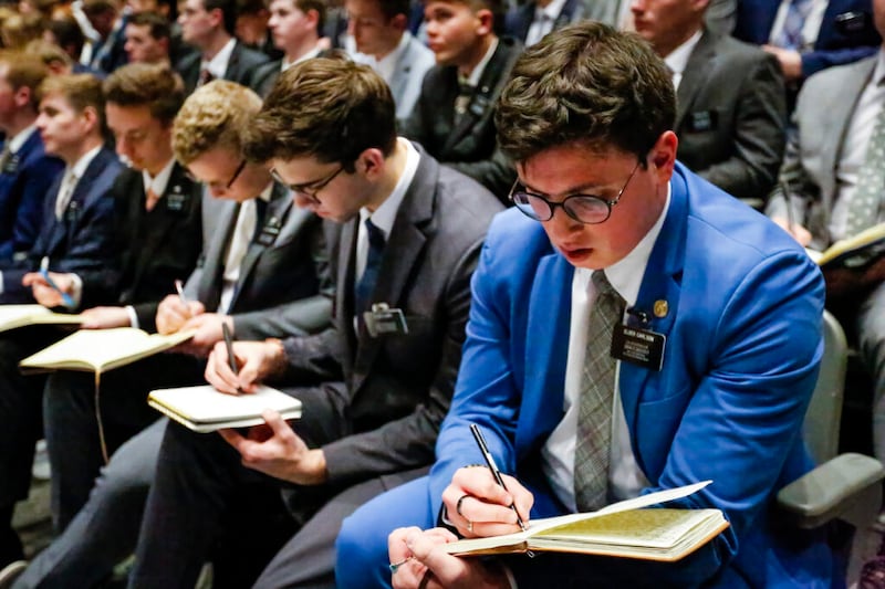 Missionários fazem anotações enquanto Élder Dale G. Renlund, do Quórum dos Doze Apóstolos, discursa durante um devocional no CTM em Provo, Utah, na terça-feira, dia 22 de março de 2022.