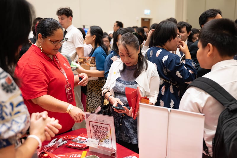 Participantes visitam o estande da BYU–Hawaii na feira de educação da Área Ásia em Bangkok, Tailândia, 19 de outubro de 2025.
