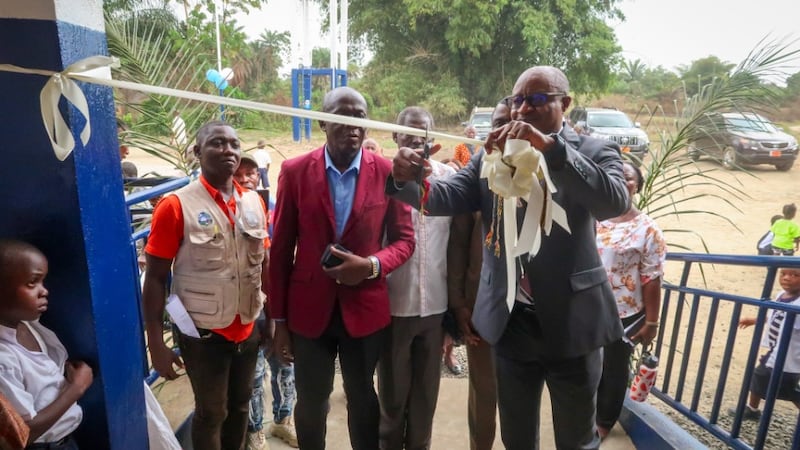 Elder Alfred Kyungu corta a fita para concluir a entrega de uma escola primária no Condado de Lower Margibi, Libéria, 21 de fevereiro de 2026.