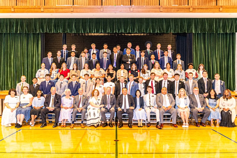Missionários da Missão Califórnia Oakland/San Francisco tiram uma foto de grupo grande ao lado do palco de uma capela durante uma conferência de zona em 2025.