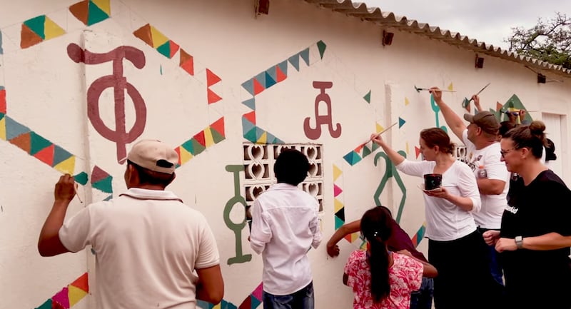 Voluntários da WaterAid juntamente com membros da comunidade Wayúu pintam símbolos antigos de "Kanaas" em nova infraestrutura de água em La Guajira, Colômbia, em um vídeo do Youtube publicado em 3 de fevereiro de 2025.