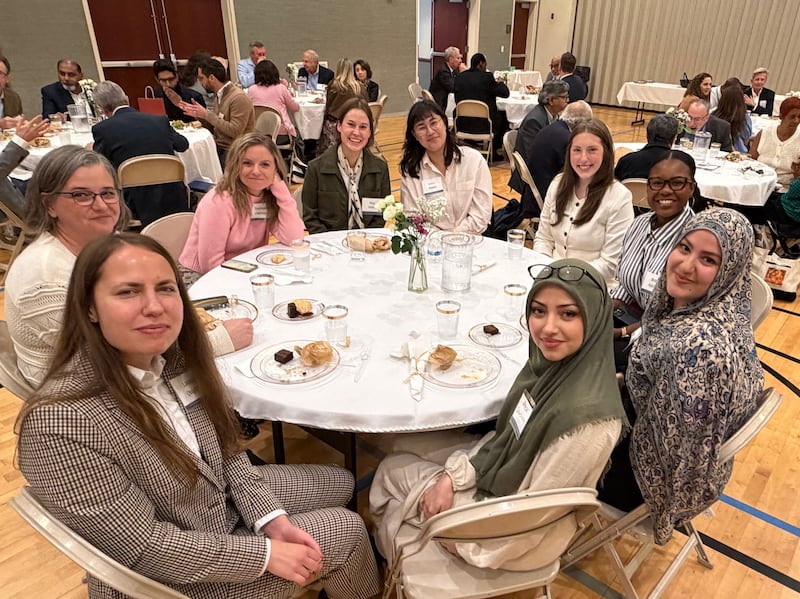Mulheres se sentam em uma mesa para comerem uma refeição juntas em um encontro inter-religioso em Chicago, Illinois, em 14 de outubro de 2026.