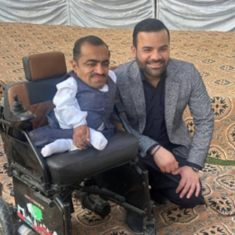 O Ministro de Estado do Paquistão Barrister Aqueel Malik posa com um beneficiário de cadeira de rodas durante um evento de entrega em 13 de fevereiro de 2026, em Taxila City, Paquistão.