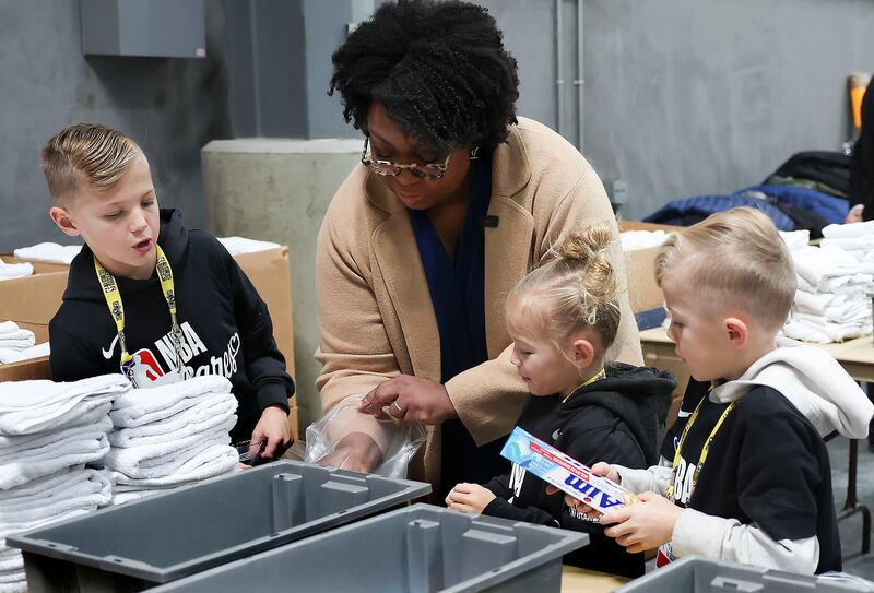 A irmã Tracy Y. Browning, segunda conselheira na presidência geral da Primária de A Igreja de Jesus Cristo dos Santos dos Últimos Dias, embala kits de higiene com Jet, Violet e Jude Smith, no Armazém Central do Bispo em Salt Lake City, na sexta-feira, fevereiro 17 de janeiro de 2023, como parte do NBA Cares All-Star Day of Service.