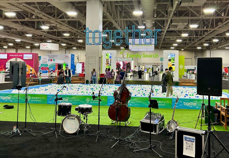 Um cartaz com a palavra "Together", o tema da RootsTech 2026, está pendurado no salão de exposições.