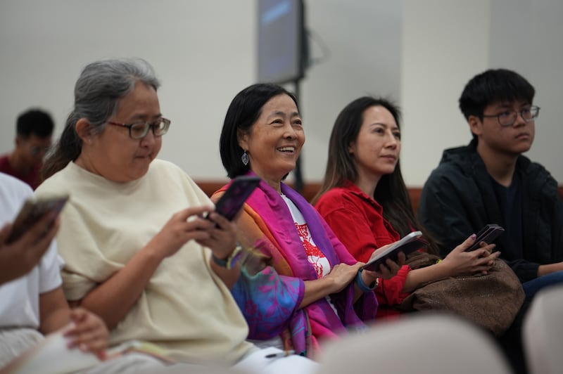 Jasmin Choy e seu filho, à direita e segundo da direita, participam de jogos de aprendizagem durante a sessão de informações da feira de educação da Área Ásia em Kuala Lumpur, Malásia, 25 de outubro de 2025.
