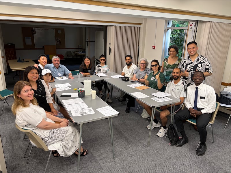 Professores, alunos e missionários sorriem para uma fotografia durante uma aula de EnglishConnect no edifício da Bournemouth Ward no Southampton England Stake na terça-feira, 14 de julho de 2026.