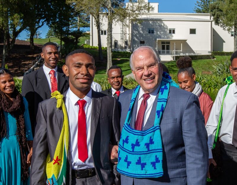 Élder Ronald A. Rasband do Quórum dos Doze Apóstolos usa uma bolsa chamada bilum dada a ele por 11 futuros missionários da Papua-Nova Guiné.