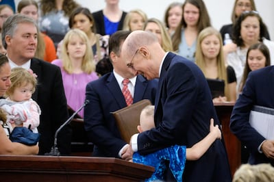 Presidente Henry B. Eyring abraça uma garotinha após a conferência da estaca Charlotte Carolina do Norte Centro.