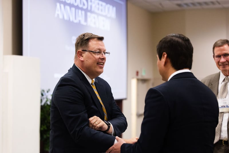 Élder Clark G. Gilbert, Setenta Autoridade Geral de A Igreja de Jesus Cristo Santos dos Últimos Dias, fala com um participante durante a Conferência Anual de Liberdade Religiosa de 2023, no Centro de Conferências da BYU em Provo, Utah, em 15 de junho de 2023.