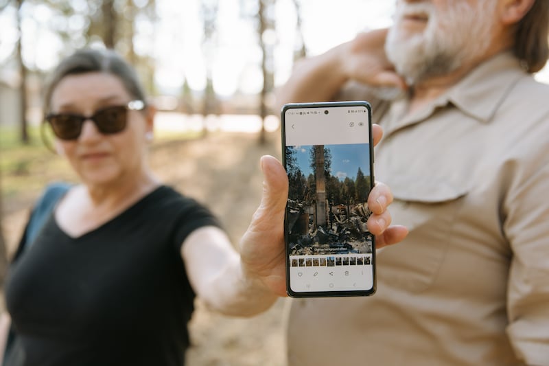 Cherie Tolman segura uma fotografia mostrando o que restou de sua casa após ser destruída pelos incêndios florestais de Spokane no início de agosto em Spokane, Washington, no sábado, 22 de agosto de 2026.
