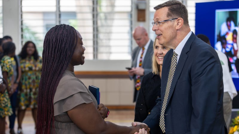 Élder Clark G. Gilbert do Quórum dos Doze Apóstolos, à direita, e sua esposa, Irmã Christine Gilbert, atrás dele, saudam os alunos do BYU-Pathway após o devocional em Acra, Gana, na sexta-feira, 28 de agosto de 2026.