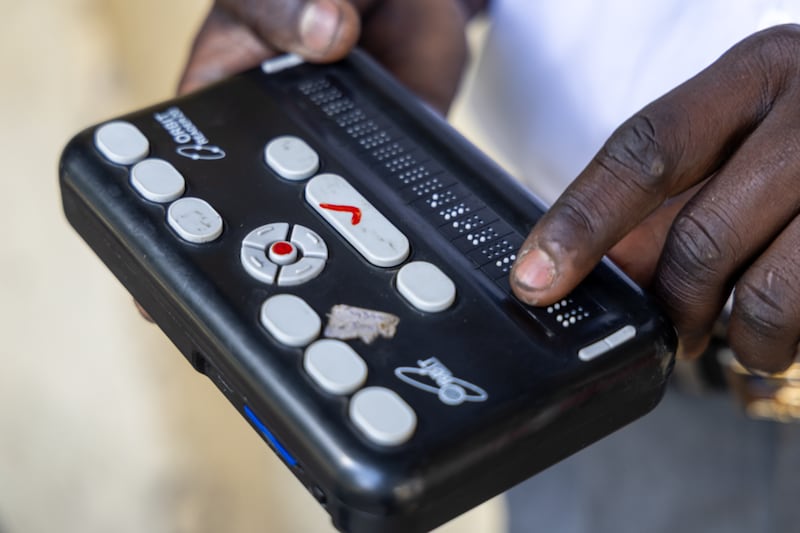 Um estudante demonstra como um orbit reader, uma ferramenta digital de braille, funciona, em 16 de janeiro de 2026, em Kisumu, Quênia. A Igreja de Jesus Cristo dos Santos dos Últimos Dias e outras organizações comunitárias doaram 87 orbit readers para a Kibos Special Secondary School, uma escola para estudantes cegos e deficientes visuais de Kisumu.