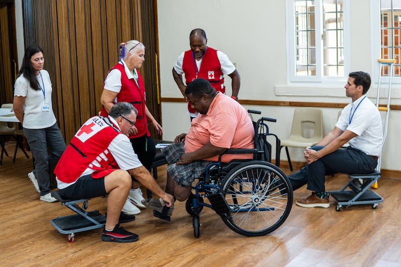 Voluntários ajudam a ajustar uma cadeira de rodas doada por A Igreja de Jesus Cristo dos Santos dos Últimos Dias como parte de uma doação maior de centenas de cadeiras de rodas na Bolívia em 2026.