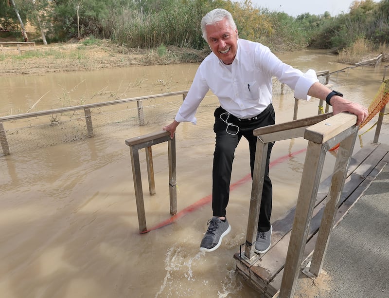 Élder Dieter F. Uchtdorf, do Quórum dos Doze Apóstolos de A Igreja de Jesus Cristo dos Santos dos Últimos Dias, molha o sapato no rio Jordão em Qasr al-Yahud, perto de Jericó, Israel, na quarta-feira, 19 de abril de 2023.