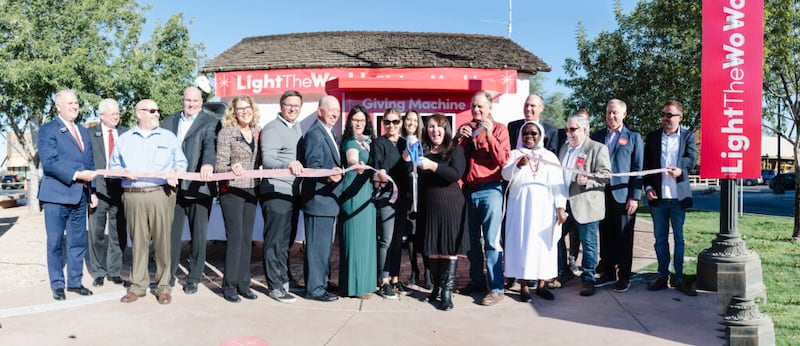 Líderes locais da Igreja, cívicos e representantes de instituições de caridade cortam a fita para inaugurar oficialmente as Máquinas de Doações no Water Tower Plaza em Gilbert, Arizona na segunda-feira, 29 de novembro de 2021.