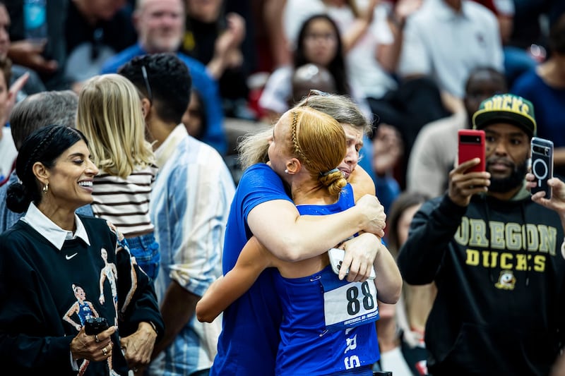 Jane Hedengren, da BYU, recebe um abraço após vencer um título nacional na corrida de 5.000 metros.